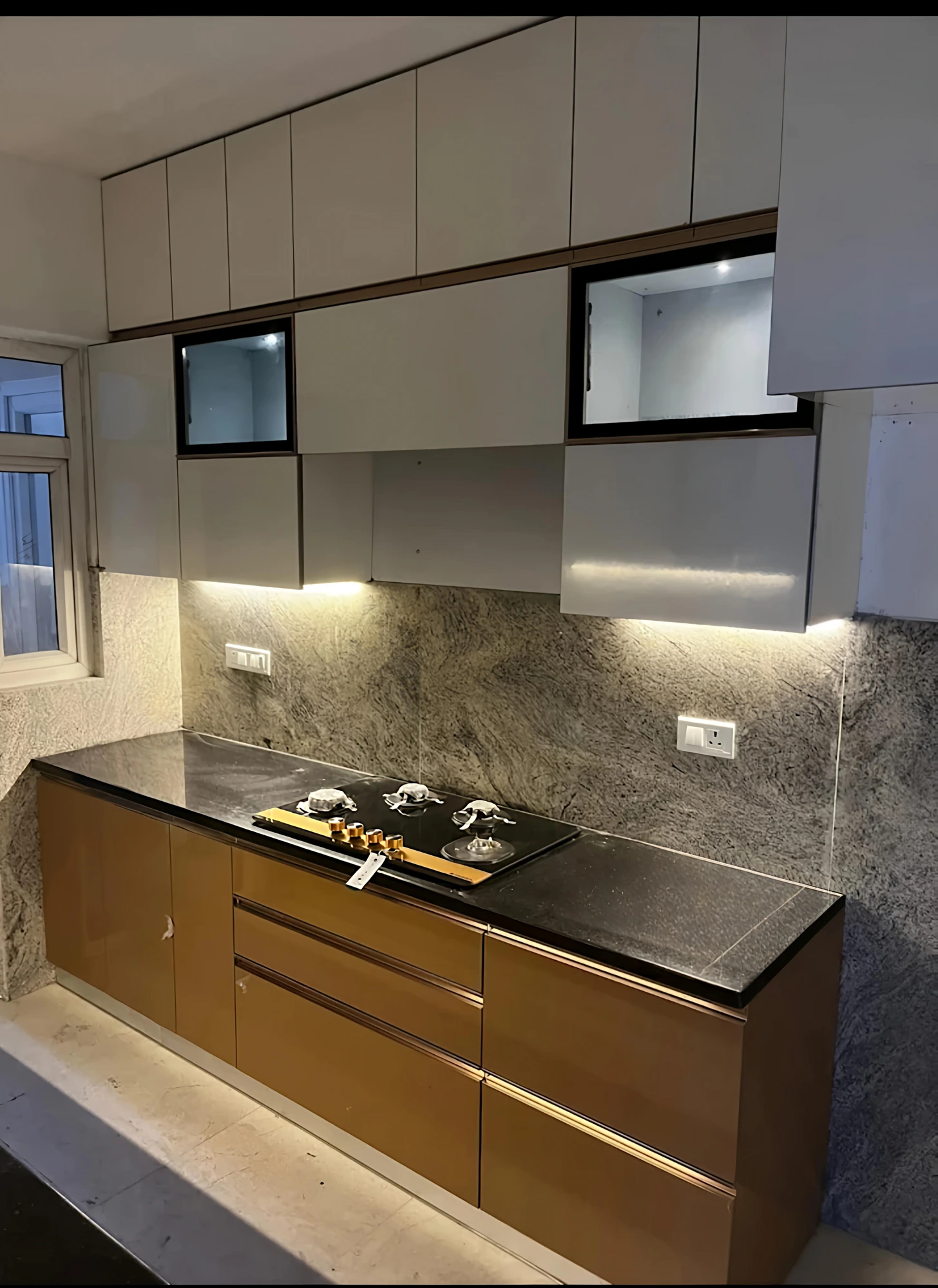 Handleless kitchen with marble backsplash and glass wall cabinets