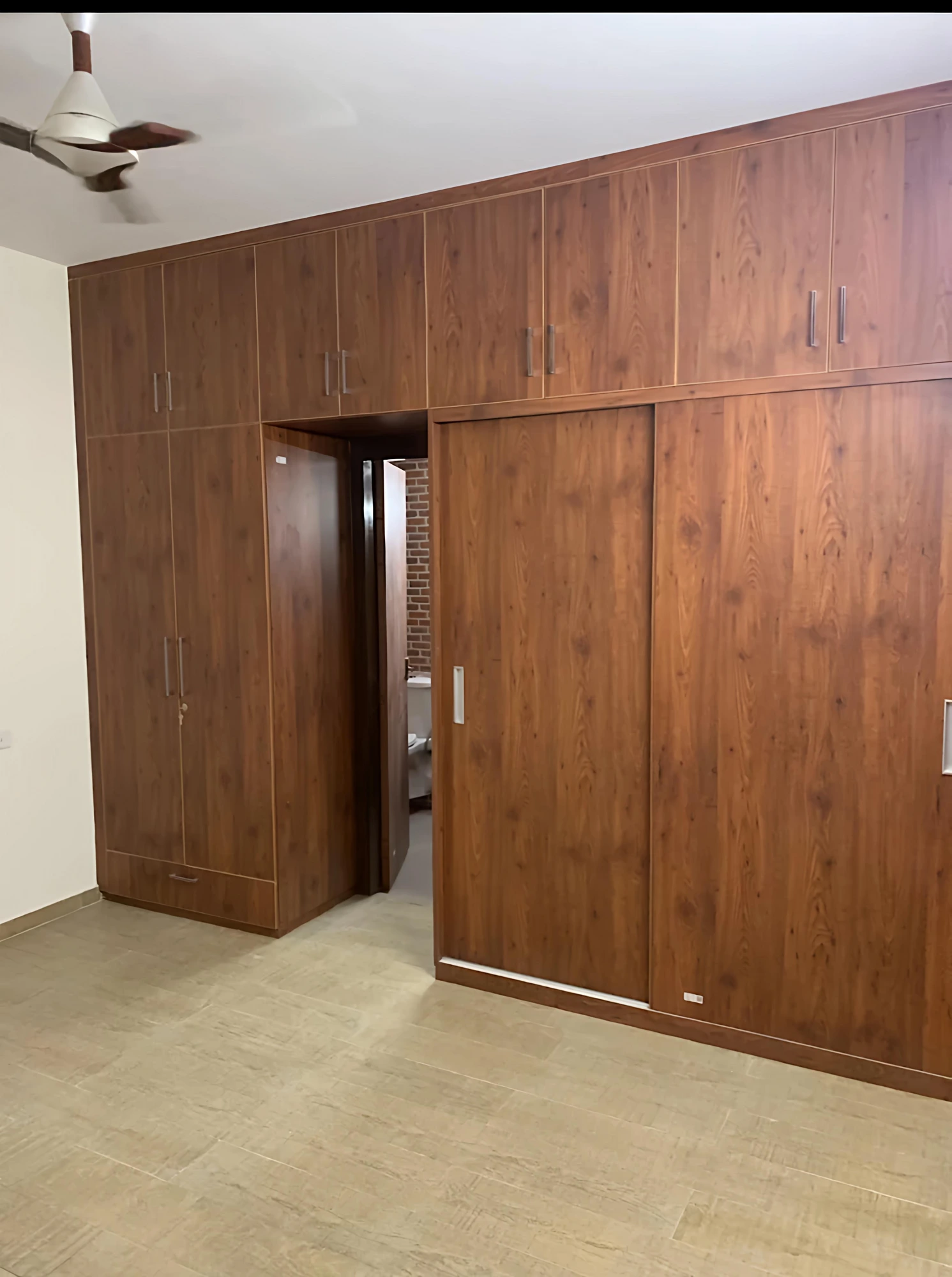 Full-wall walnut sliding wardrobe